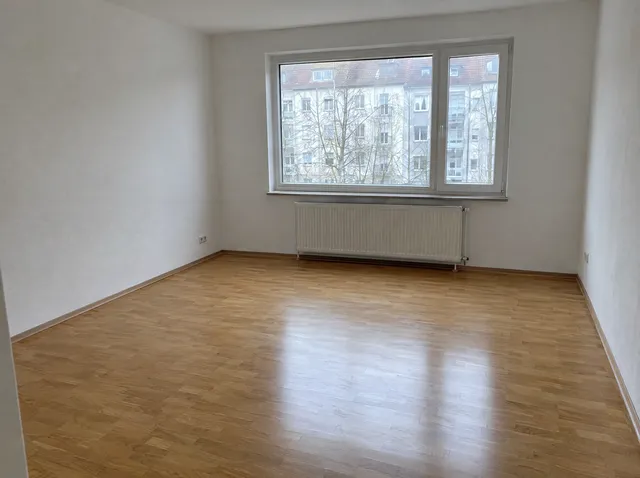 Leerer Raum mit Parkett und großem Fenster